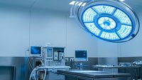 Modern operating room with LED surgical light and medical equipment for healthcare procedures and sterile environment operations.