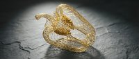 Dried physalis fruit with papery golden husk on dark textured surface, suitable for food photography, botanical styling, and natural product design projects.