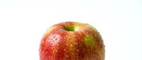 Fresh red apple with water droplets on white background isolated for healthy eating and nutrition concepts.