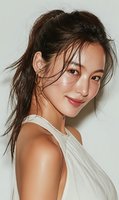 Young Asian woman with wet hair in messy ponytail wearing white sleeveless top smiling at camera with natural makeup and glowing skin for beauty campaigns.