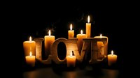 Wooden LOVE letters surrounded by glowing candles on dark background, warm romantic atmosphere for Valentine's Day or anniversary celebration.