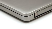 Sleek silver laptop corner closeup showing brushed metal texture and hinge detail, isolated on white background for tech and electronics design use.