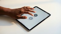 Close-up of dark-skinned hand touching tablet screen with loading icons, representing digital interaction, technology use, and user engagement for apps and websites.