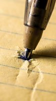 Fountain pen nib writing on lined paper with blue ink, creating handwritten marks on cream-colored sheet for writing, correspondence, and calligraphy projects.