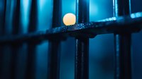 Glowing white sphere balanced on dark metal bars against deep blue background creates mysterious atmospheric mood for conceptual designs and presentations.