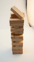 Wooden blocks tower game with falling pieces on neutral background representing strategy, balance, risk management and business planning concepts.
