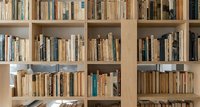 Wooden bookshelf filled with diverse collection of books in neutral tones, perfect for educational content, reading concepts, and literary backgrounds.
