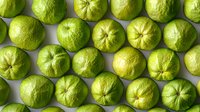 Fresh green limes arranged in neat rows on light gray background, top view. Citrus fruits pattern showing natural texture and vibrant color for food and drink designs.