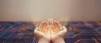 Open hands holding glowing lightbulb symbolizing innovation, creativity and bright ideas for business solutions and inspiration concepts.