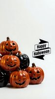 Stacked carved jack-o-lantern pumpkins with glowing faces and black decorative pumpkins on white background with Happy Halloween banner text.