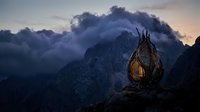 Glowing lantern sits on rocky mountain peak at dusk with dramatic storm clouds and jagged peaks in moody twilight landscape setting.