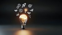 Glowing light bulb with business icons floating above on dark background representing innovation, creativity and entrepreneurial ideas for marketing campaigns.