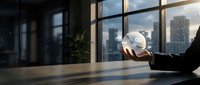 Businessman holding glowing transparent sphere with digital icons in modern office, city skyline background, futuristic technology concept.