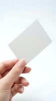 Hand holding blank white card against clean background for business presentation mockup design templates.