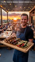 Smiling Caucasian male chef holds grilled skewers and vegetables on wooden board at rooftop restaurant during golden sunset.