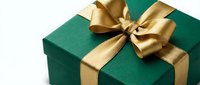 Elegant green gift box with luxurious gold satin ribbon bow on white background, perfect for holidays, birthdays, celebrations and special occasions.