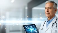 Senior Caucasian male doctor with gray hair holding digital tablet displaying medical technology interface in modern hospital setting for healthcare innovation.