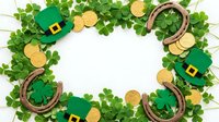 St. Patrick's Day frame with shamrock leaves, leprechaun hats, gold coins and horseshoes on white background for festive holiday decorations.