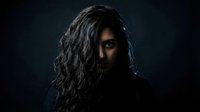 Mysterious man with long dark hair partially covering face in dramatic lighting against black background for creative projects.