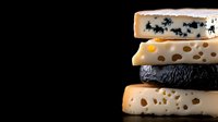 Stack of assorted gourmet cheese varieties on black background, featuring blue cheese, swiss, aged cheddar and brie. Dramatic side lighting highlights texture.