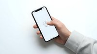 Hand holding modern smartphone with blank white screen and loading icon, isolated on white background for mockup design and app presentation.