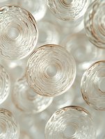 Abstract circular shapes with concentric ripple patterns in soft beige and white tones create an elegant minimalist composition with depth and texture.
