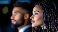 Young woman with braided hair and blue highlights in profile, wearing professional attire in corporate setting for business, leadership, and diversity concepts.