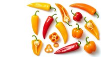 Colorful hot chili peppers and bell peppers isolated on white background. Fresh organic vegetables for cooking spicy dishes and healthy meals.