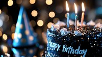 Chocolate birthday cake with lit candles and blue frosting decorations against blurred bokeh lights background, festive celebration atmosphere.