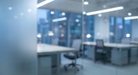 Blurred modern office interior with desks, chairs and bright lighting creating professional workspace atmosphere for business presentations.