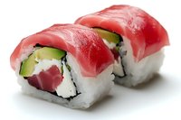Fresh tuna sushi rolls with avocado and cream cheese on white rice, garnished with raw fish on top, traditional Japanese cuisine served on white background.
