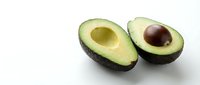 Fresh ripe avocado halves with pit on clean white background isolated for healthy cooking and nutrition design projects.