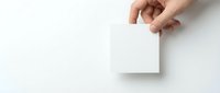 Hand holding blank white square card mockup on clean background for branding design projects and business presentations.