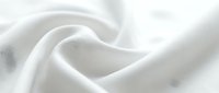 Close-up of soft white fabric with smooth folds and gentle waves, showcasing texture and light reflection for textile, fashion, and design projects.