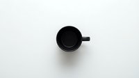 Empty black mug with handle on white background, isolated kitchenware for design mockups, merchandise templates, and product presentations.