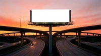 Blank white billboard mockup above a busy highway interchange at sunset, with warm orange and pink sky, for advertising and branding use.