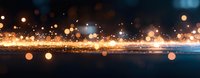Glowing golden particles and bokeh lights create magical atmosphere against dark background, abstract festive panoramic composition for holiday designs.