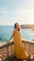 Young woman in yellow sundress enjoying peaceful moment on Mediterranean coastal balcony during golden hour sunset with turquoise sea view.