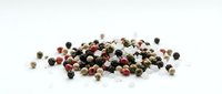 Mixed peppercorns scattered on white background showing black white green and pink pepper varieties for culinary seasoning and spice cooking applications.