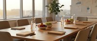 Modern conference room with wooden table set for business meeting featuring water bottles, notebooks and natural lighting from large windows.