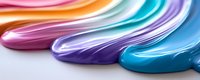 Vibrant multicolored liquid paint strokes flowing in smooth waves with glossy finish on white background for modern creative design projects.