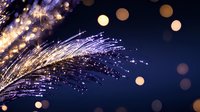 Glowing fiber optic strands with sparkles against dark blue background create magical atmosphere with golden bokeh lights and illuminated particles.