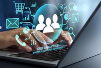 CRM analytics concept with businessman hands typing on laptop surrounded by glowing customer data icons and digital marketing symbols on dark background.