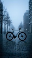 Modern fixed-gear bicycle parked on wet urban street with contemporary apartment buildings and bare trees in misty morning light, suitable for cycling, transportation, and lifestyle concepts.