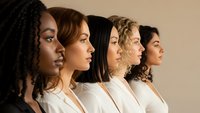 Diverse group of women in profile view wearing white clothing representing unity, teamwork and female empowerment in modern workplace or community setting.