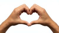 Two hands forming heart shape gesture isolated on white background expressing love affection and care for romantic concepts and emotional designs.