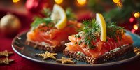 Festive smoked salmon appetizers on rye bread with dill and lemon slices, served on elegant plate against holiday background with bokeh lights.