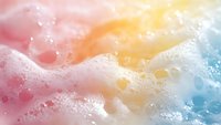 Colorful soap bubbles and foam in pastel pink, yellow, and blue tones create an abstract, dreamy texture. Isolated on white background, suitable for wellness, beauty, and design projects.