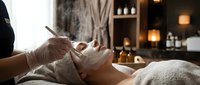 Young woman receiving relaxing facial treatment at luxury spa with candles and serene atmosphere for wellness and self-care rejuvenation.