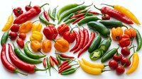Colorful assortment of fresh chili peppers in red, green, yellow and orange varieties arranged on white background. Hot spicy peppers for cooking and seasoning.